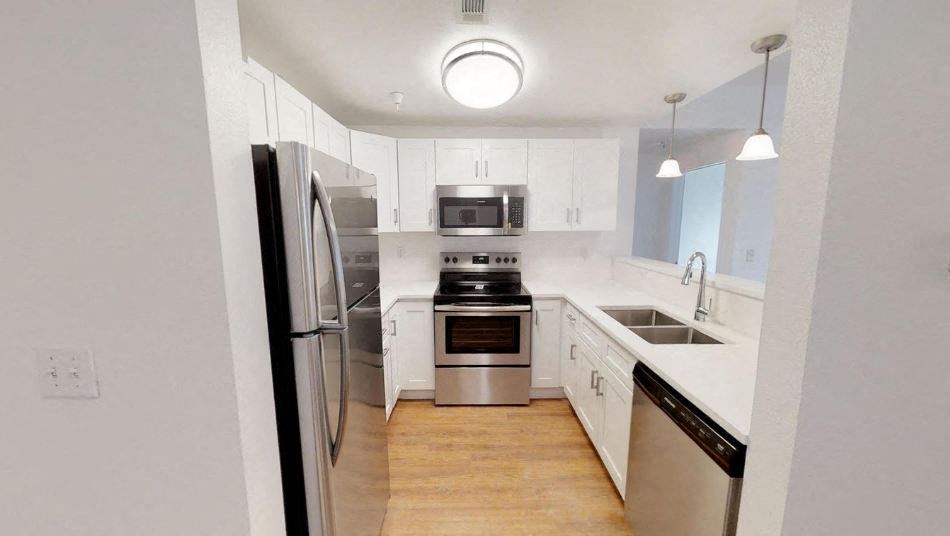 a kitchen with white cabinets and stainless steel appliances