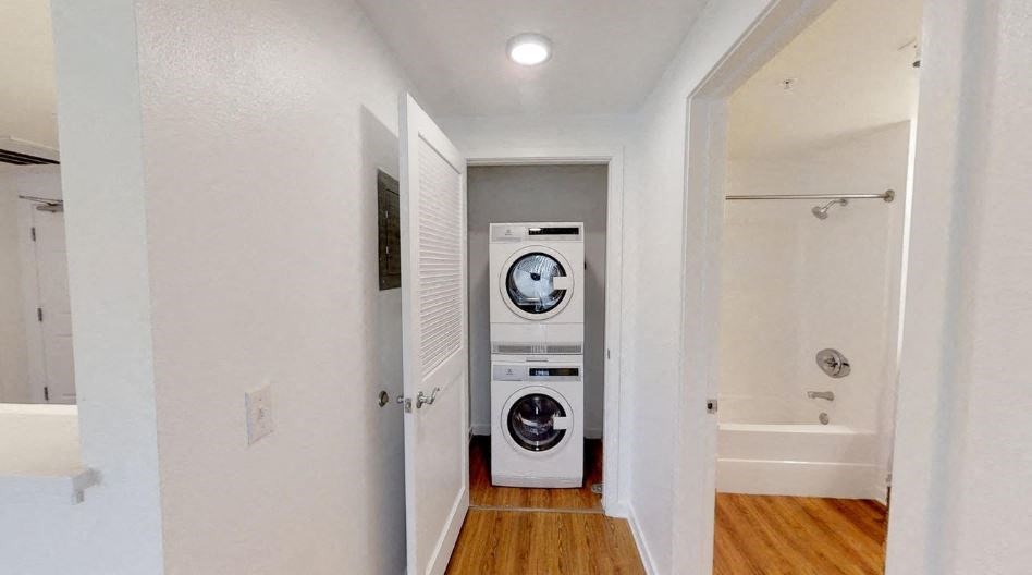a white room with a washing machine and a bathroom