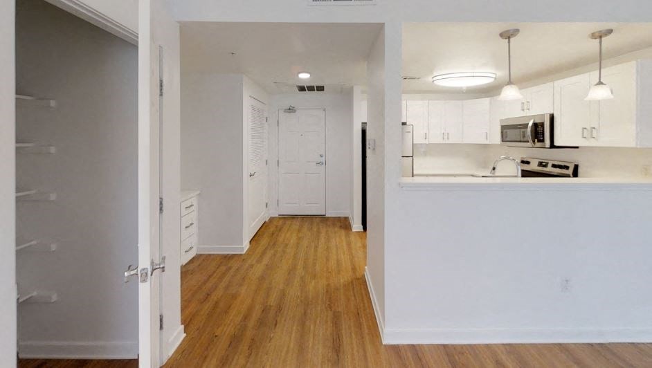 an empty kitchen and living room with an open door