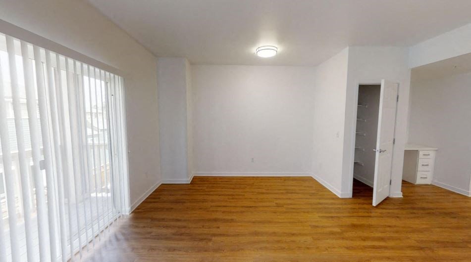 an empty living room with white walls and wood floors