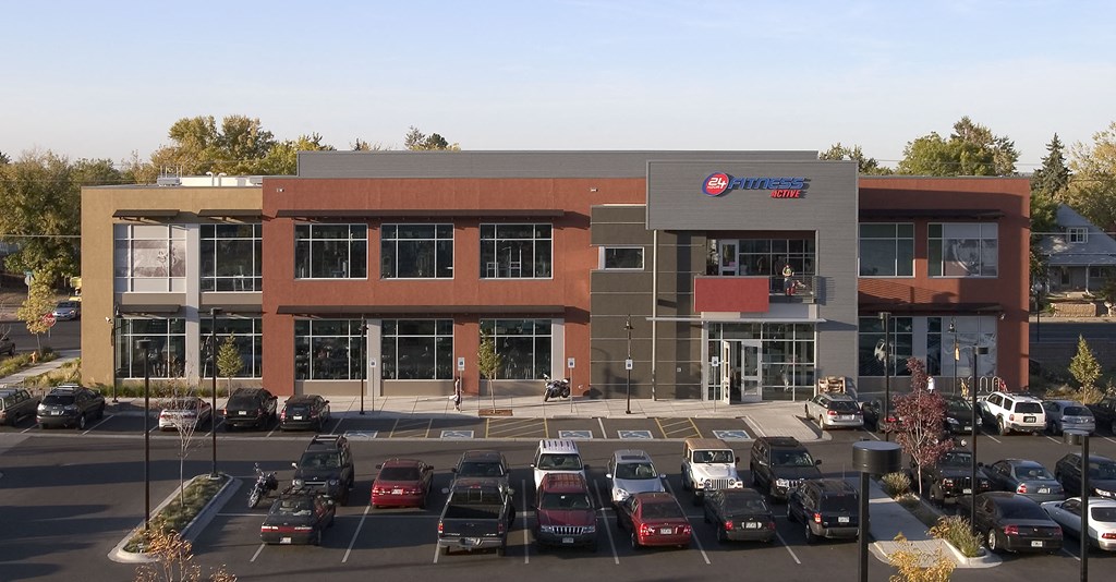 an office building with a parking lot full of cars