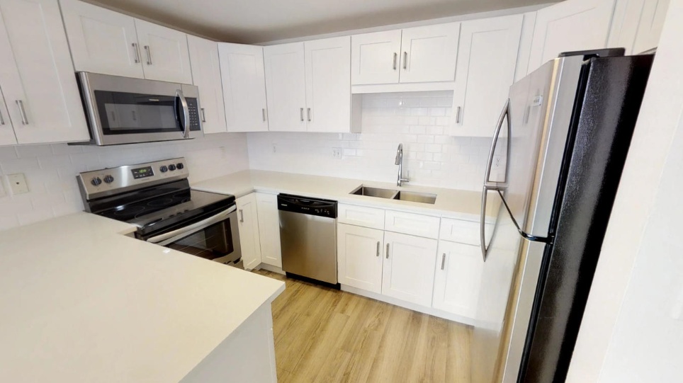 a kitchen with white cabinets and stainless steel appliances
