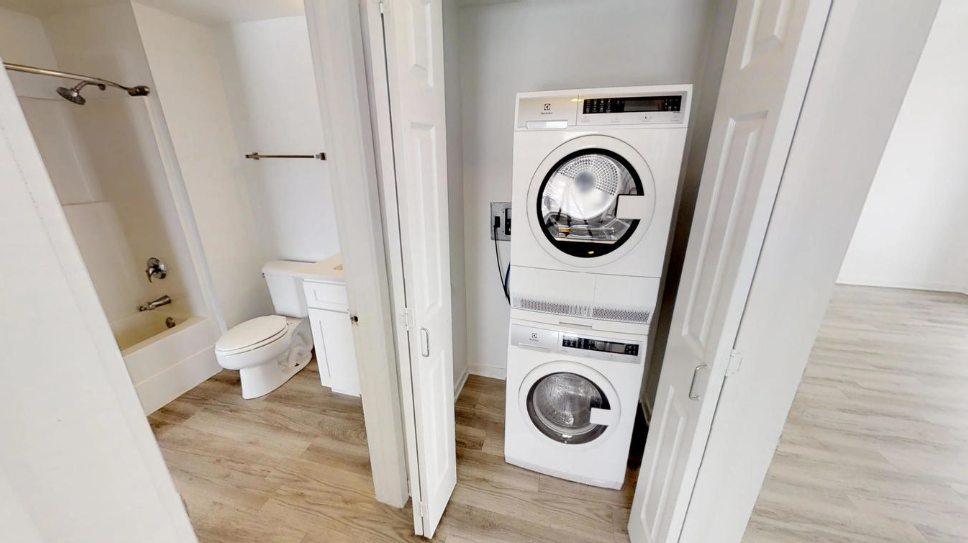 a small bathroom with a washing machine and a toilet