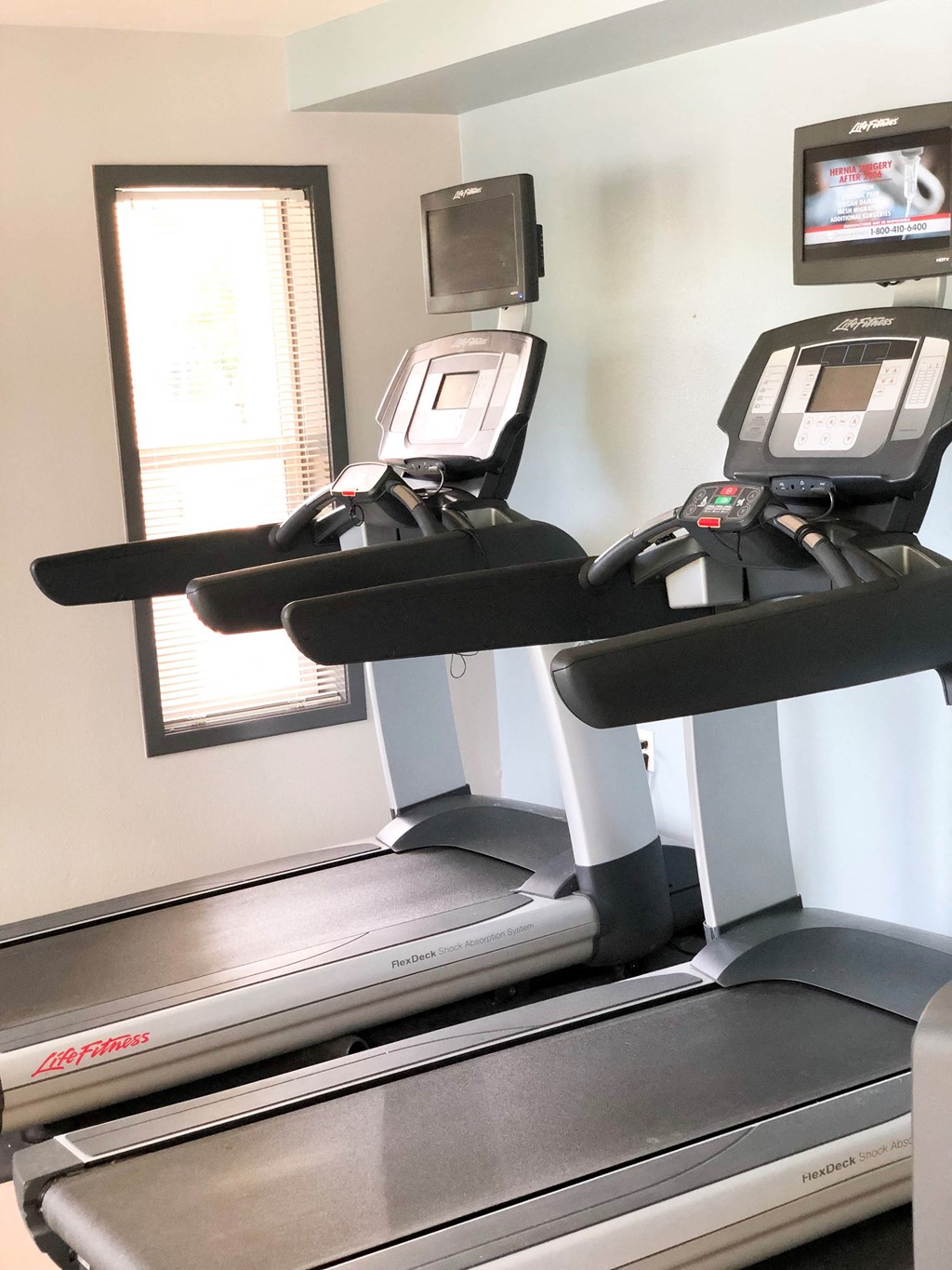 a treadmill in a gym with a tv on it
