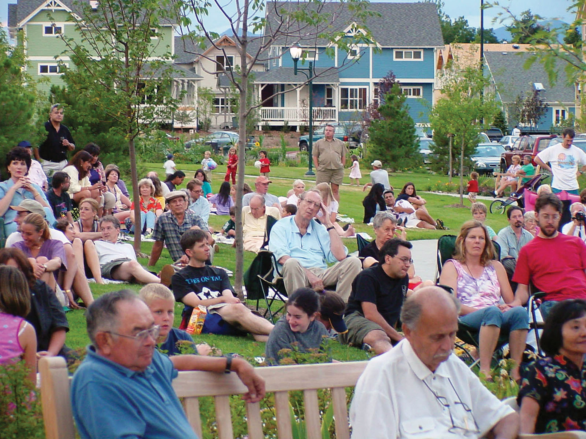 a crowd of people sitting on benches in a park