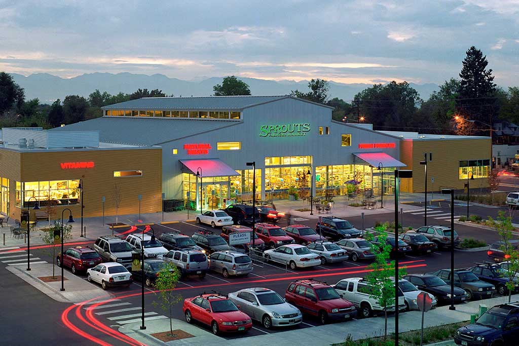 a parking lot full of cars in front of a shopping center