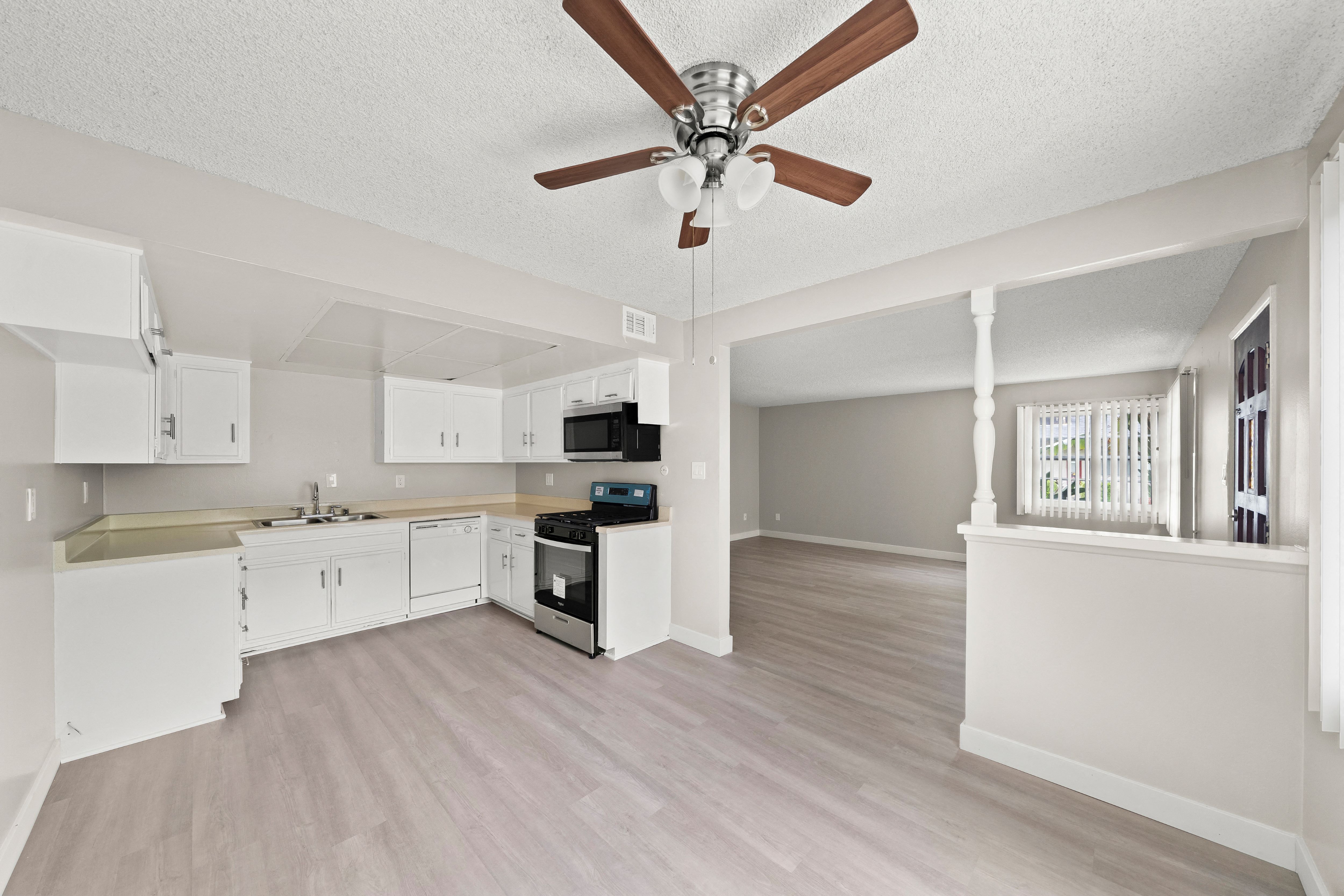 an open kitchen and living room with a ceiling fan