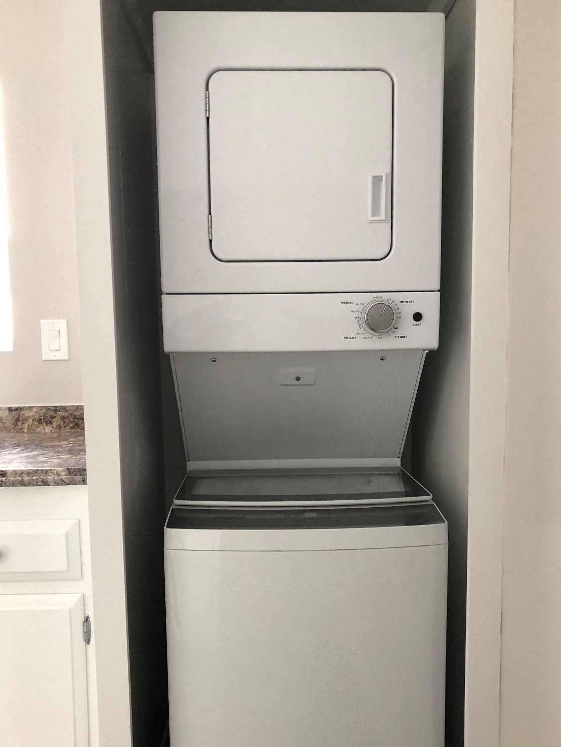 A white dishwasher is sitting in a kitchen.