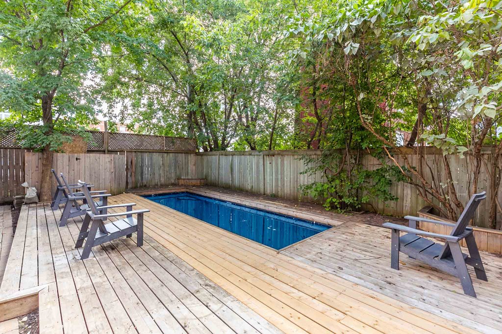 a pool in a backyard with a deck and chairs