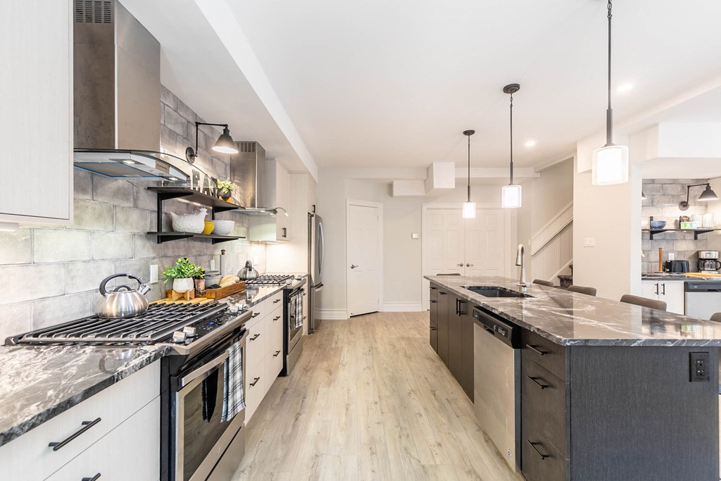 a kitchen with stainless steel appliances and marble counter tops