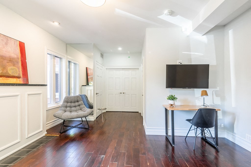 a living room with a chair and a desk with a tv