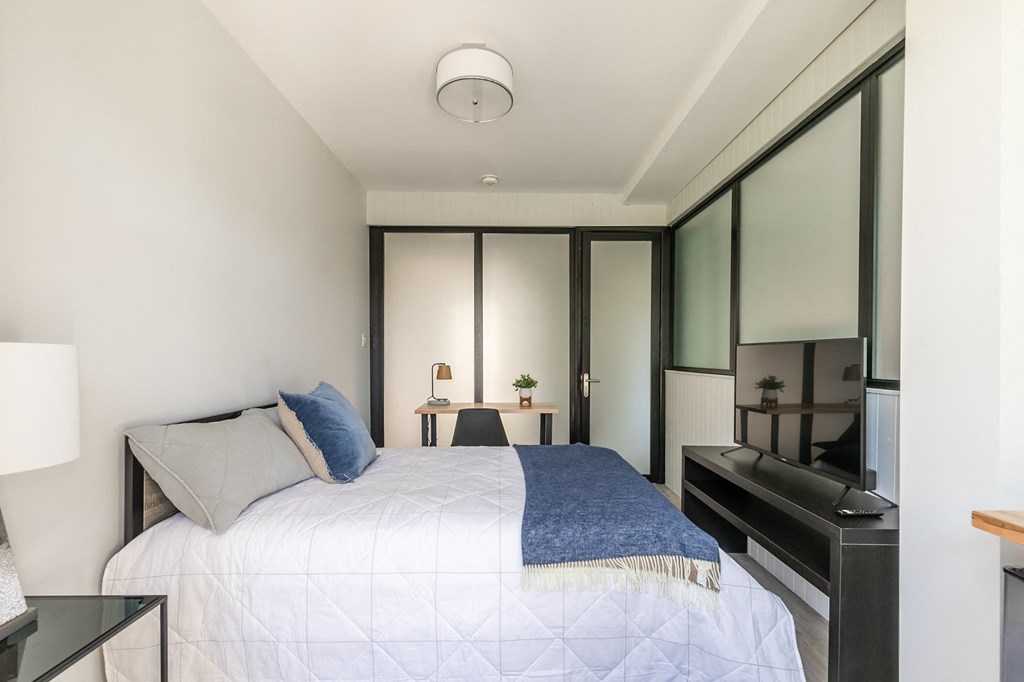 a bedroom with a large bed and a black piano