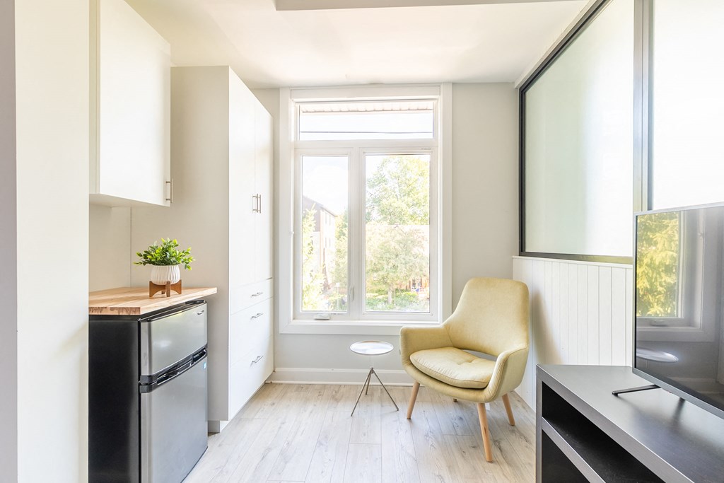 a small kitchen with a chair and a window