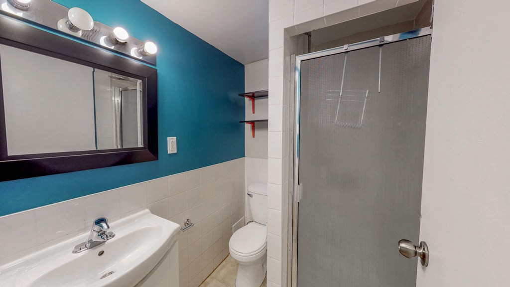 a bathroom with a shower and a sink and a mirror