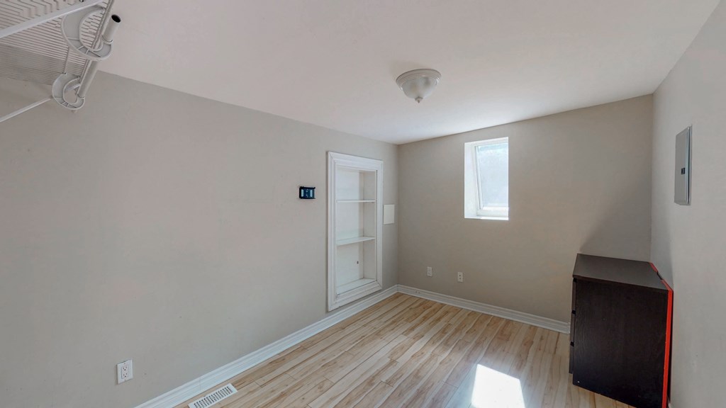 a empty room with wood floors and a door to a closet