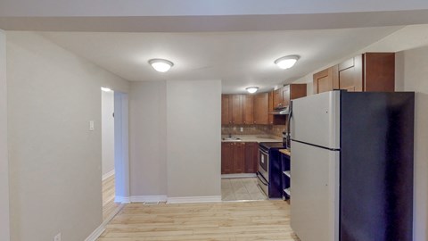 a kitchen with wood flooring and a refrigerator