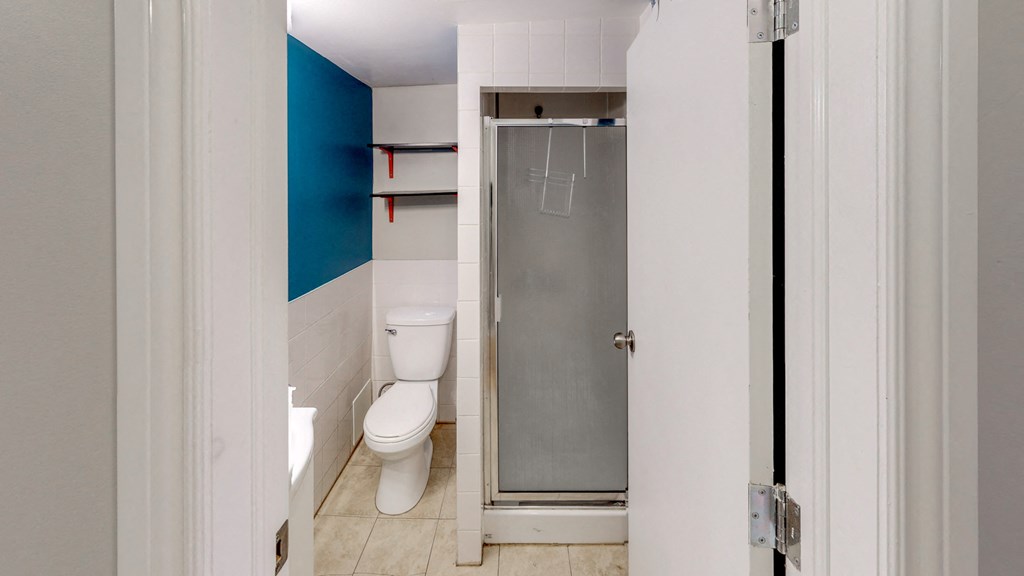 a bathroom with a toilet and a shower