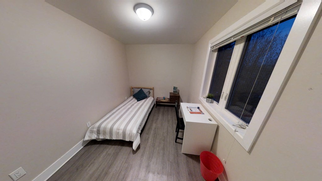 a small bedroom with a bed and a window