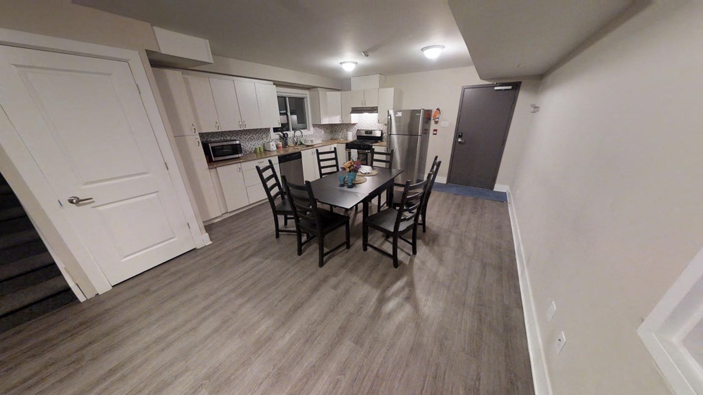 a view of a dining room and kitchen in an apartment