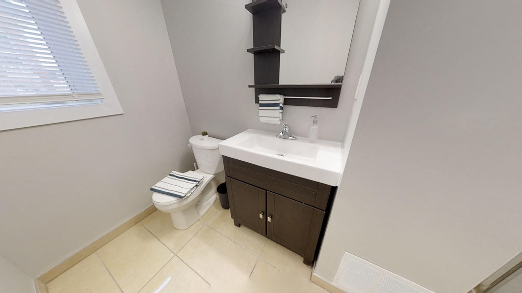 a bathroom with a toilet and a sink and a window