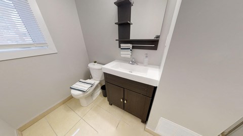 a bathroom with a toilet and a sink and a window