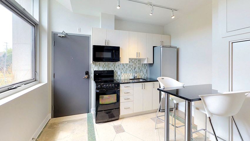 a small kitchen with a table and chairs and a refrigerator