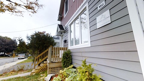 the side of a house with a wooden porch and a window
