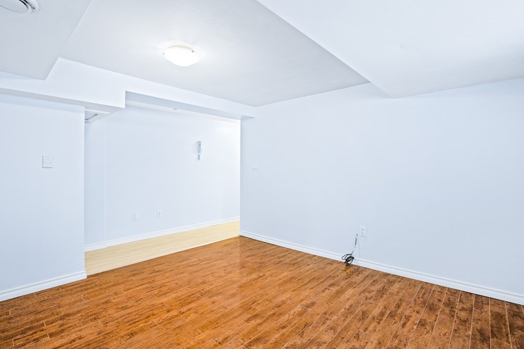 an empty room with wood floors and white walls