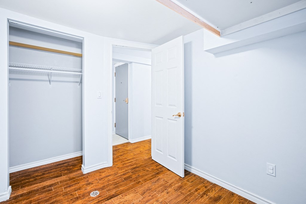 a bedroom with wood floors and blue walls and a closet