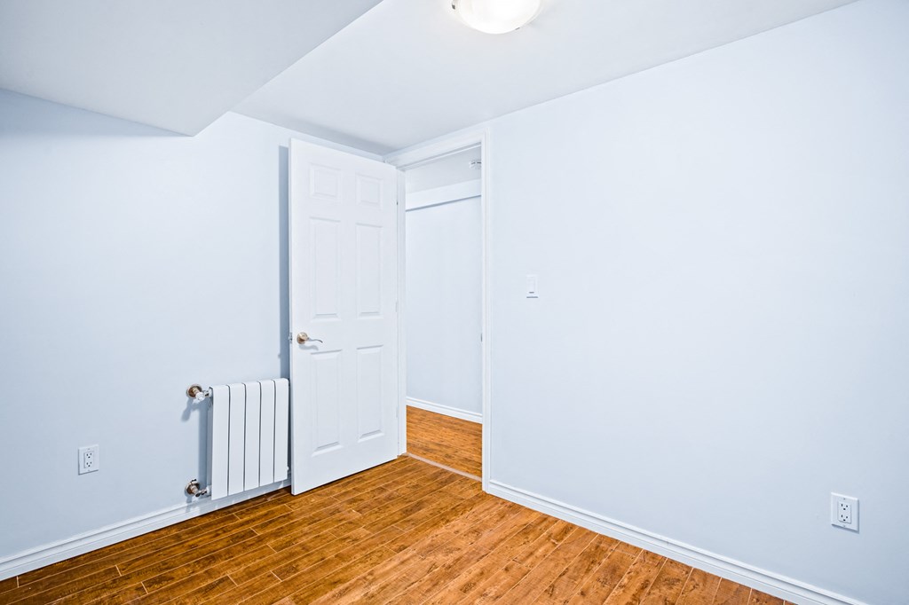 an empty room with wood floors and a white door