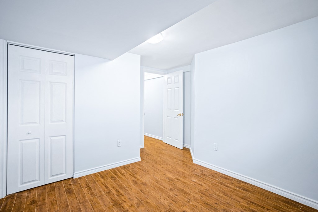 an empty room with white walls and wood floors