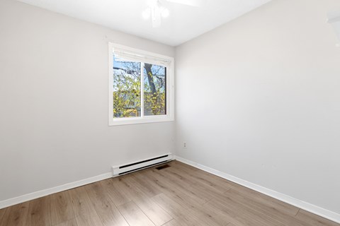 an empty room with white walls and a window