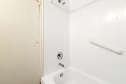 a white bathroom with a shower and a sink