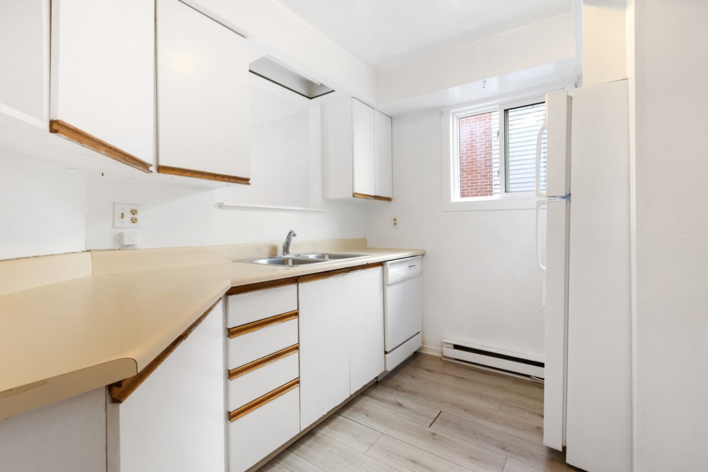 a kitchen with white cabinets and a sink and a refrigerator
