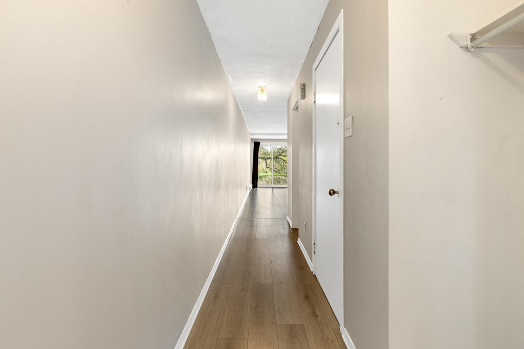 a long white hallway with white walls and wood floors