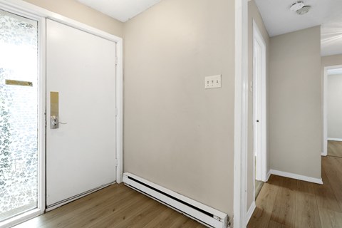 an empty room with white walls and a sliding glass door