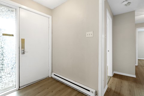 an empty room with white walls and a sliding glass door