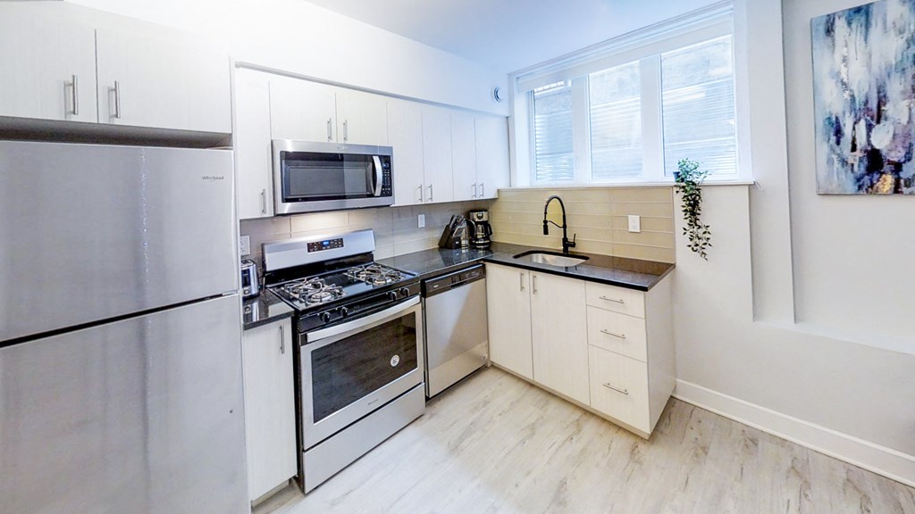 a modern kitchen with stainless steel appliances and white cabinets