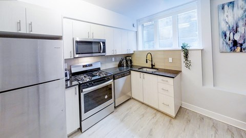 a modern kitchen with stainless steel appliances and white cabinets