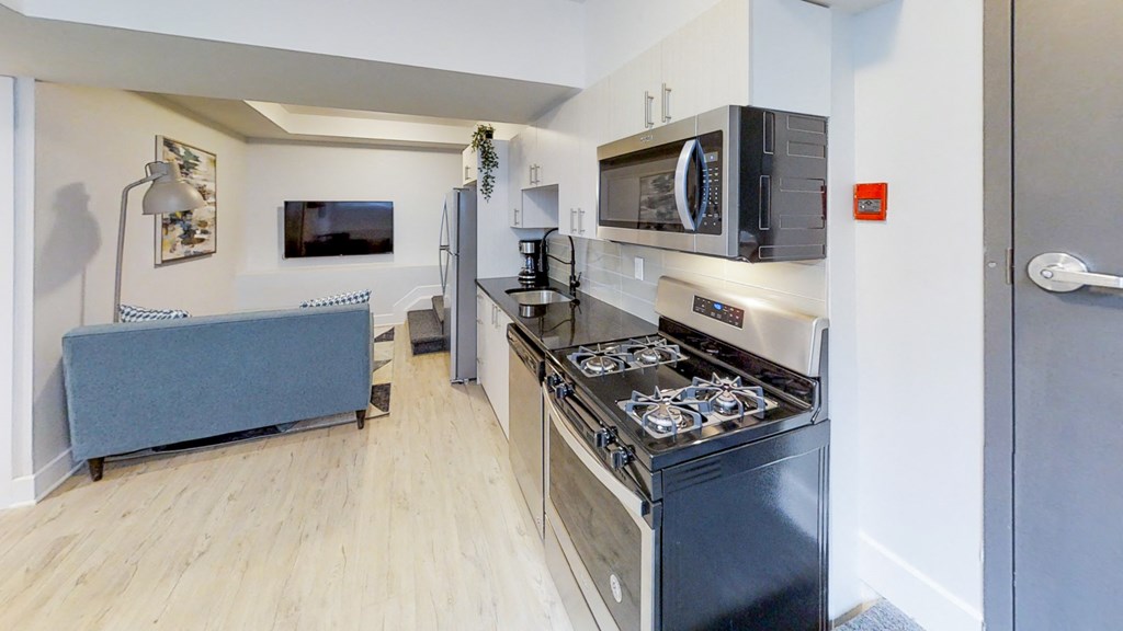 a renovated kitchen with stainless steel appliances and a microwave