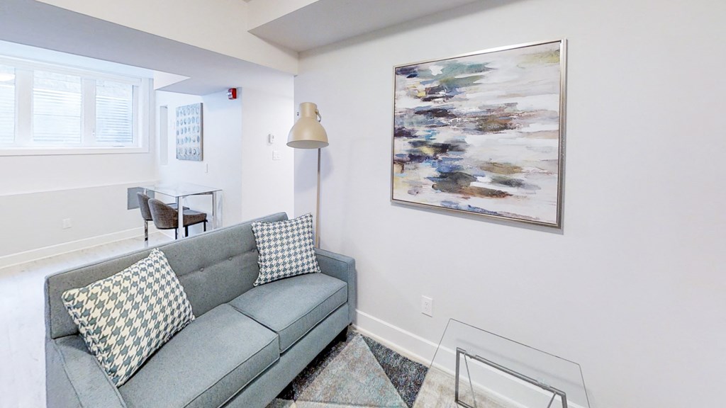 a living room with a couch and a painting on the wall