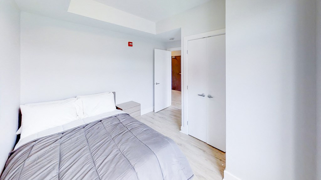 a bedroom with a bed and a door to a bathroom