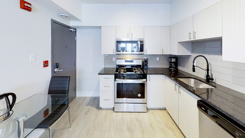 a kitchen with white cabinets and stainless steel appliances