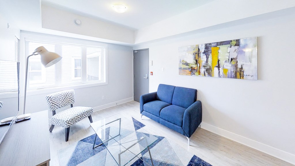 a living room with a blue couch and a glass table