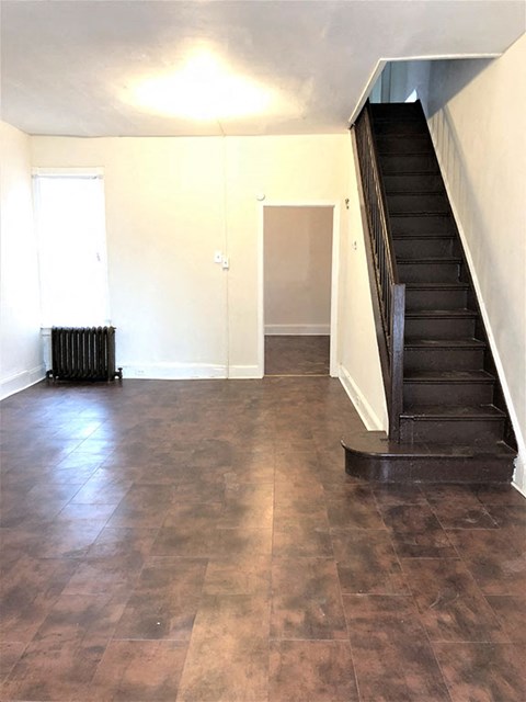 A room with a staircase and a radiator.