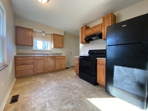 a kitchen with black appliances and wooden cabinets