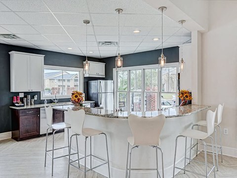 a kitchen with a counter and chairs and a sink