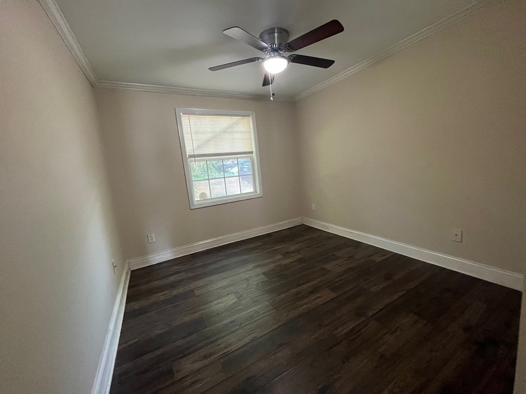an empty room with a ceiling fan and a window