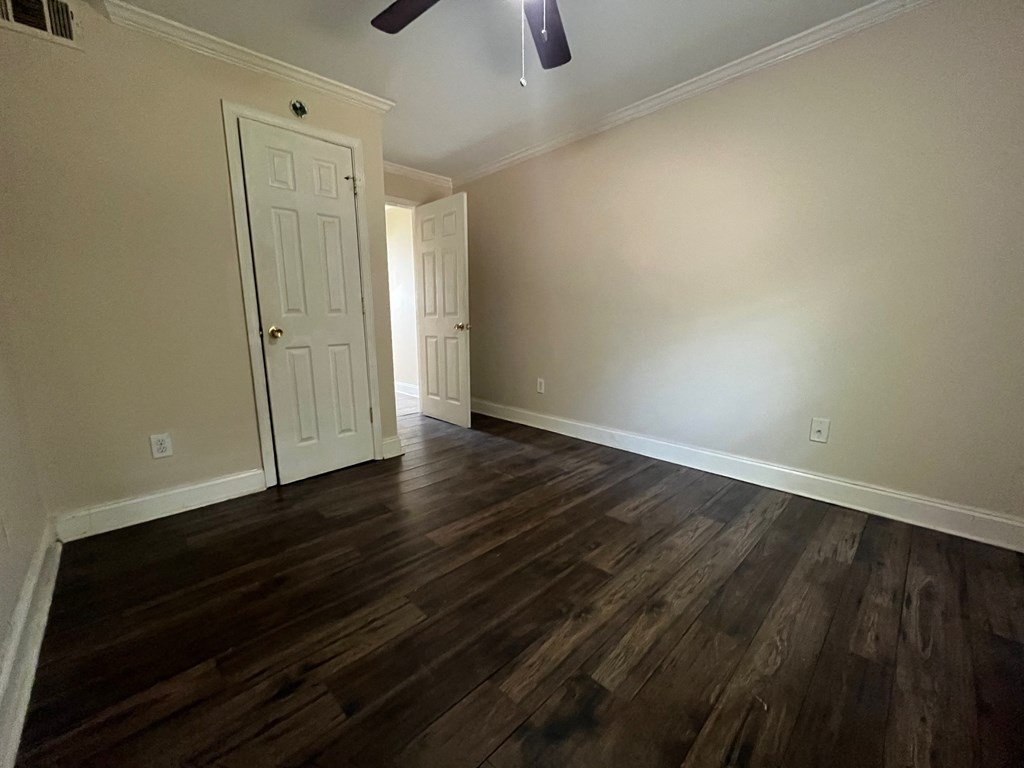 a living room with hard wood floors and a white door
