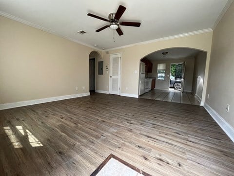 a living room with wood floors and a ceiling fan